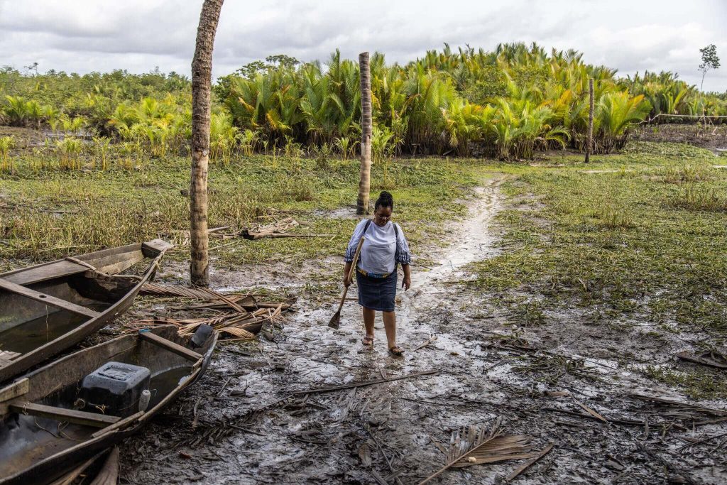 Martha Agbani returning from the planting site.Credit...Yagazie Emezi for The New York Times